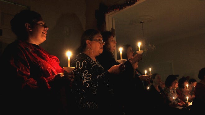 Stancey Randall, left, and Rosalie Maez are illuminated by glowing candles during the Lights of Remembrance event Dec. 12, 2013, at the Brewer Lee and Larkin Funeral Home.