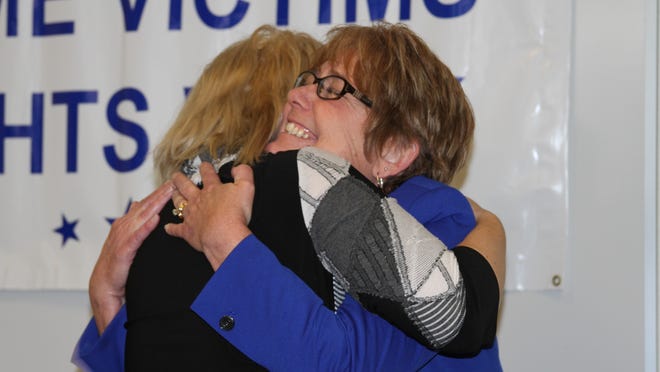 Michigan Department of Corrections staffer Kelley Gonsler, in blue, hugs Wendy Morrison during the county prosecutor’s office’s Above and Beyond Award Ceremony lunch at the Judicial Center on Highlander Way in Howell on Wednesday. Gonsler was recognized for her work in keeping the man who kidnapped and assaulted Morrison in 1993 behind prison bars.