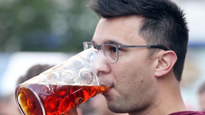 Alex Schulze, of West Chester, enjoys a beer at Oktoberfest Zinzinnati last year.
