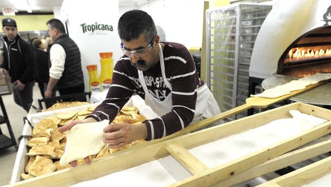 Saad Aziz of Sterling Heights, originally of Baghdad, bakes fresh bread at the Paradise Fruit Market in Troy. The city has passed Dearborn as having Metro Detroit’s second biggest percentage of foreign-born residents, census numbers show.