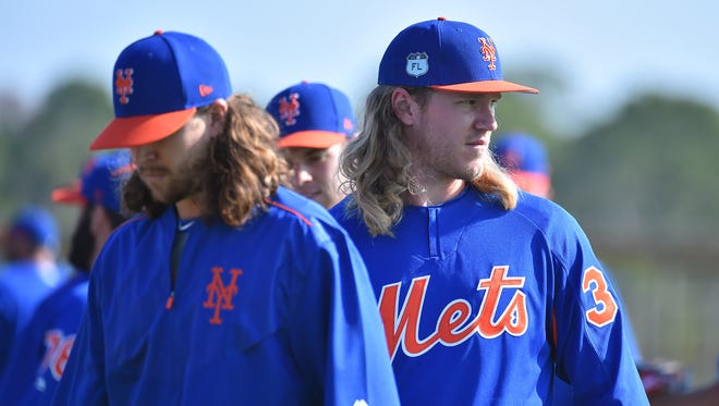 Mets starting pitcher Noah Syndergaard, right, looks on during spring training workouts at Port St. Lucie, Fla.
