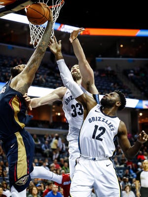 Memphis Grizzlies defenders Marc Gasol (middle) and Tyreke Evans (right) battle New Orleans Pelicans forward DeMarcus Cousins (left) for a rebound during fourth quarter action at the FedExForum in Memphis, Tenn., Wednesday, January 10, 2017.