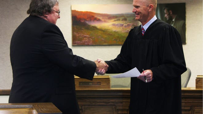 Fifth District Court Judge Keith Barnes congratulates Cedar City Councilman Ron Adams after being sworn-into another term at the Cedar City Offices, Tuesday, Jan. 2, 2018.