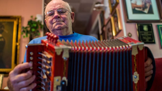 Cajun musician Walter Mouton plays a song on his accordion at his home in Scott, La., Tuesday, Nov. 10, 2015. 