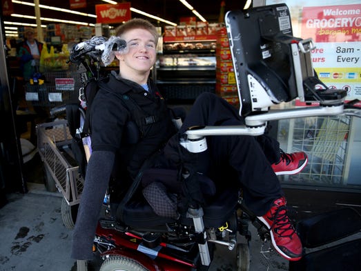 Scott Taber, 19, pulls a wagon with his wheelchair