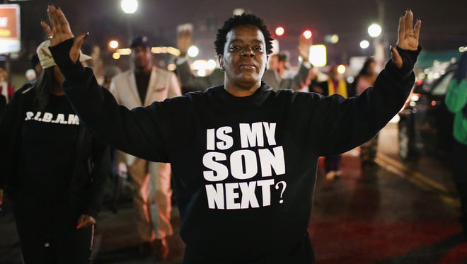 Demonstrators protest in front of the police station on March 12 in Ferguson, Missouri. Two police officers were shot yesterday while standing outside the station observing a similar protest.