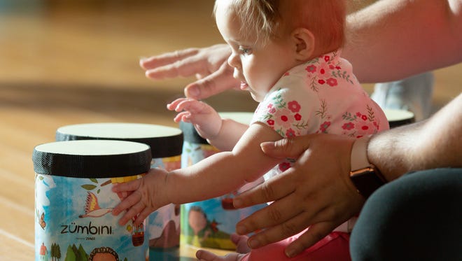 Mackenzie Miller, 7-months-old, plays with the drums during a Baby Zumbini class at La Buena Vida Women's Club on Wednesday, April 11, 2018.