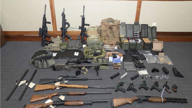 This image provided by the U.S. District Court in Maryland shows a photo of firearms and ammunition that was in the motion for detention pending trial in the case against Christopher Paul Hasson. Prosecutors say that Hasson, a Coast Guard lieutenant is a "domestic terrorist" who wrote about biological attacks and had a hit list that included prominent Democrats and media figures.
