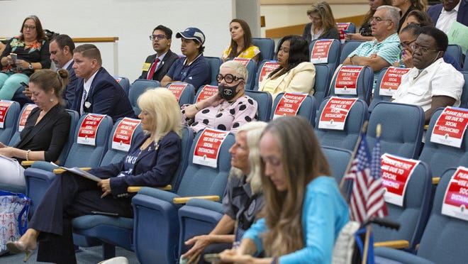 A group of maskless opponents of the the wearing of masks sit in the audience at the Palm Beach County Commission meeting Tuesday, June 23, 2020 where commissioners unanimously voted to require people to wear masks in public.