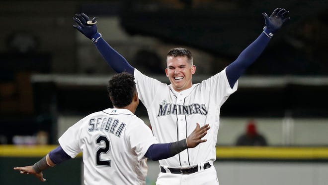 Ryon Healy, right, is greeted by Jean Segura after his 11th inning single gave the Mariners  a 9-8 win over the Angels on May 5 in Seattle.
