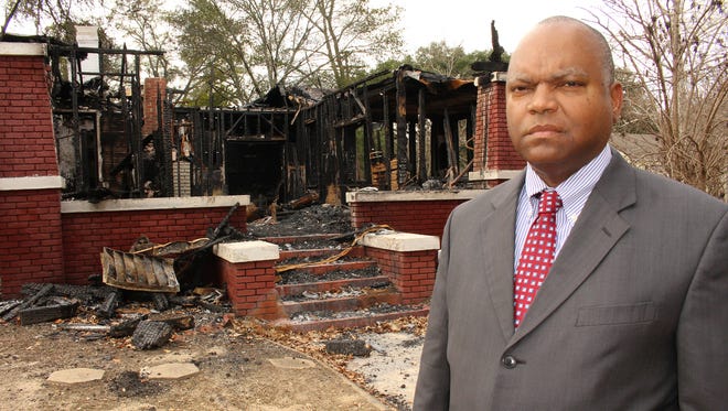 Dallas County District Attorney Michael Jackson stands next to torched house that claimed the lives of a mother and her disabled daughter. Alvin Benn/Special to the Advertiser