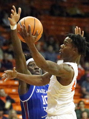 UTEP senior guard Omega Harris, 2, drives for a bucket despite the efforts of Anthony Duruji, 10, of Louisiana Tech Friday night in the Don Haskins Center. 