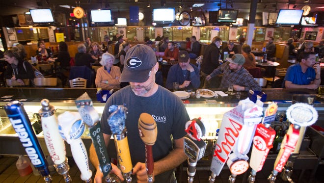 Kent Randle pours beer for the bar crowd at Ryan's Sports Grill on Harmony Road Thursday, January 26, 2017. 