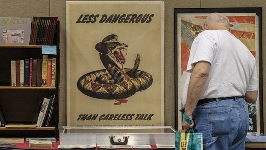 A man checks out the World War II government-sponsored propaganda posters at the Antiquarian Book & Paper Show held Sunday, Oct. 2, 2016, at the Lansing Center.