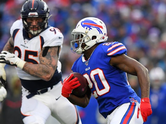 Bills running back Frank Gore carries the ball with Broncos defensive end Derek Wolfe in pursuit.