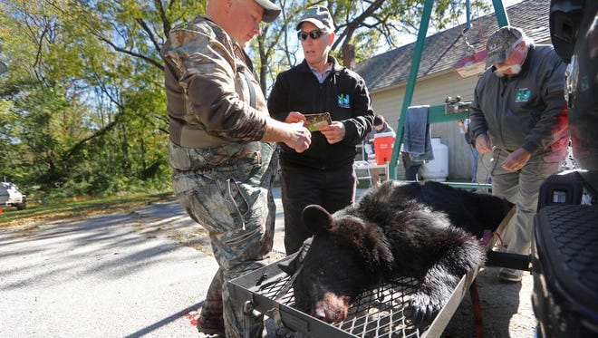 Wildlife tech Kim Tinnes speaks to a hunter at the weigh station in Fredon on Monday, the first day of New Jersey’s black bear bow and arrow hunt.