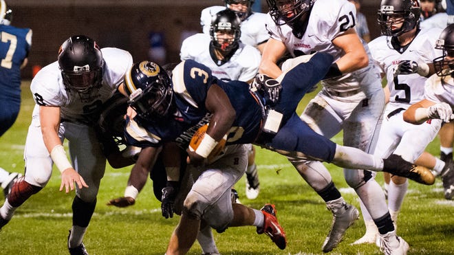Collingswood's Donny Barr (3) gets tackled by Haddonfield's Jake Robinson (21) and Tyler Klaus (8) on Friday night.