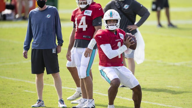 Dolphins quarterback Tua Tagovailoa throws during training camp in front of Ryan Fitzpatrick.