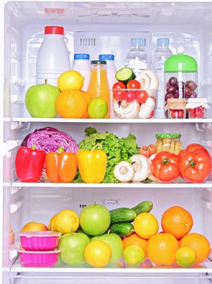 Shot of an open fridge with food products