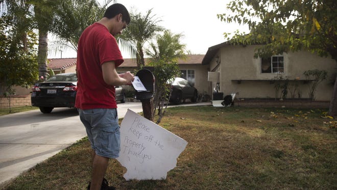 A brother of Enrique Marquez collects his mail Dec. 9, 2015, in Riverside, Calif. Authorities have said Enrique Marquez, an old friend of San Bernardino attacker Syed Farook, purchased two assault rifles used in last week's fatal shooting that killed 14 people.