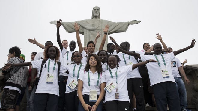 Members of the Refugee Olympic Team pose for a photo in front of the Christ the Redeemer statue in Rio de Janeiro, Brazil, Saturday, July 30, 2016. A group of 10 athletes from South Sudan, Syria, Congo and Ethiopia will compete in Rio under the Olympic flag.