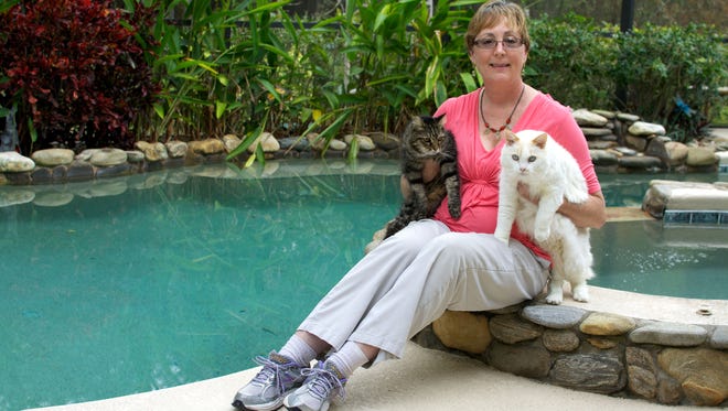 Katherine McCoy runs PURRS, which saves stray cats and helps get them adopted. Here she is with her own rescues, Emily, left, and Fred.