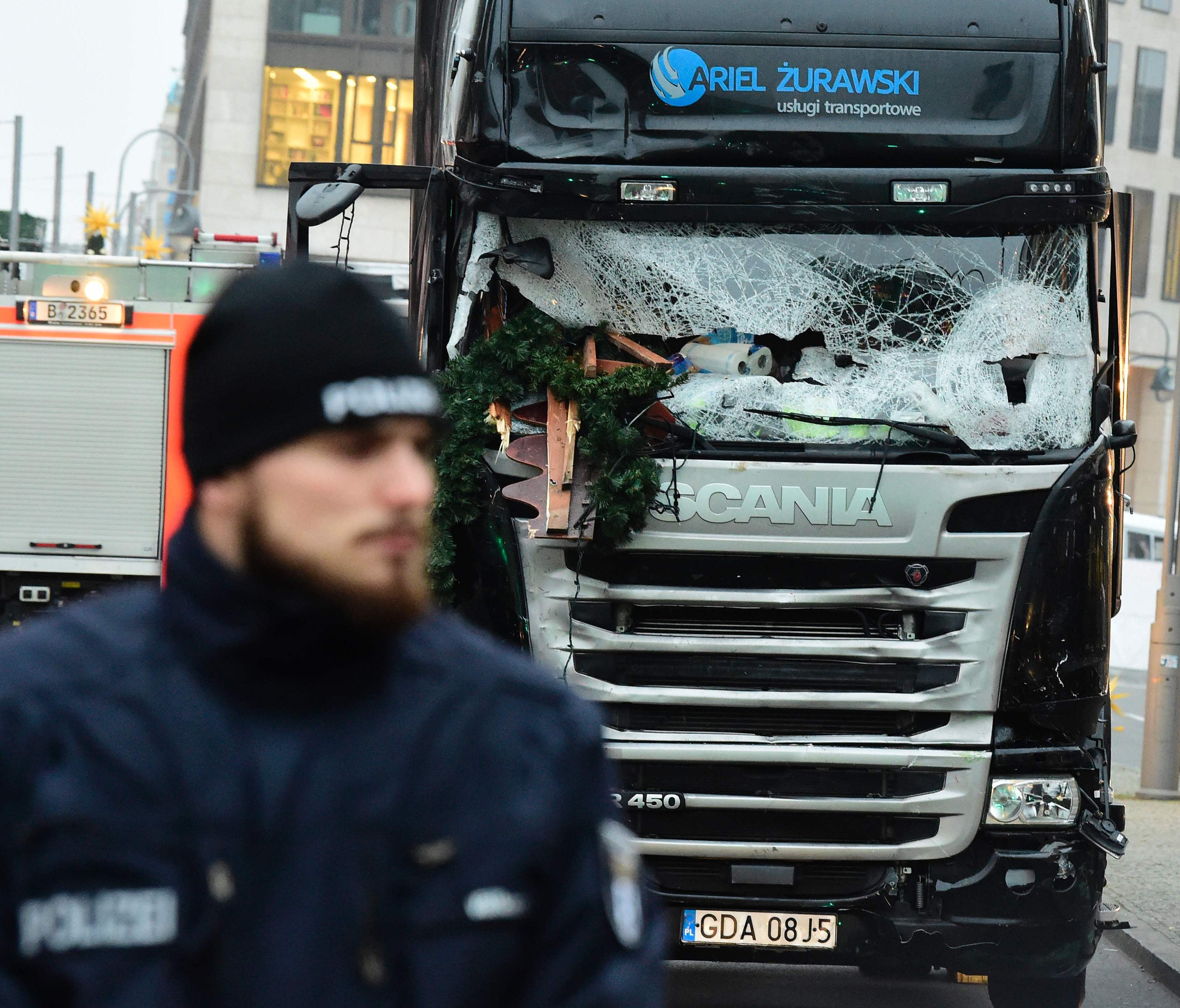 A policeman stands on Dec. 20, 2016 in front of a truck at the site where it crashed into a Christmas market near the Kaiser-Wilhelm-Gedaechtniskirche (Kaiser Wilhelm Memorial Church) in Berlin.