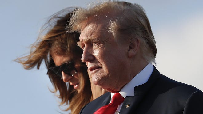 President Donald Trump and first lady Melania Trump walk down the stairs of Air Force One during their arrival at Palm Beach International Airport. Trump traveled to Florida to spend the Easter weekend as his Mar-a-Lago estate.