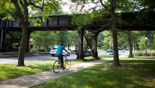
A bicyclist rides under the CSX bridge on North Main Street in Pittsford.
