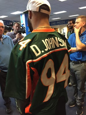 Lions receiver Golden Tate pays off a bet to Dwayne (The Rock) Johnson by wearing his Miami jersey. Tate lost the bet when his college, Notre Dame, lost to Miami recently.