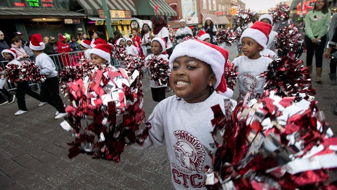 Christ Trinity Christian Academy cheerleaders including Madison Green, right, march last year in the Memphis Holiday Parade on Beale Street. The parade returns this Saturday.