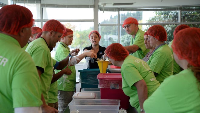 Maria Fernandez explains how to fill the meal bags to Point Beach employees including Jeff Hartwig, Aaron Ferrebee, Scott Manthei and Faye Spindler.