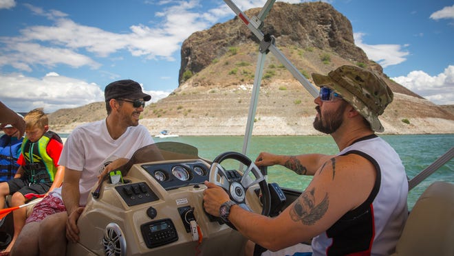 Cody Samson, right, steers a boat on Elephant Butte Lake, July 2, 2016.