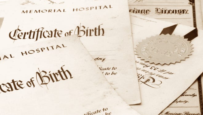 Close-up of a stack of important family papers, including birth certificates.