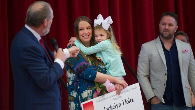 Vogel Elementary School teacher Jackelyn Holtz holds her daughter, Claire, 5, as she is congratulated by Evansville Vanderburgh School Corporation Supt. David Smith for being named the 2017 Elementary School Teacher of the Year Wednesday morning.