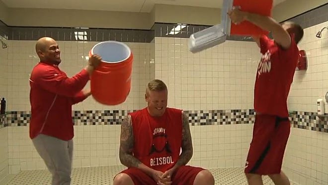 Brayan Pena and Devin Mesoraco assist Mat Latos in his effort to raise awareness for ALS.