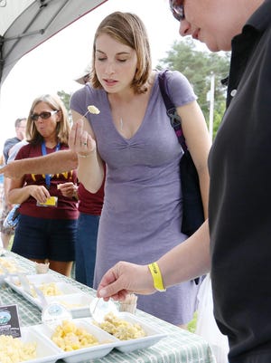 Emily Cummings, left, of Syracuse, and Kate Morse, of Geneva, sample cheese at the Engelbert Farms tent at the Finger Lakes Cheese Festival Saturday at the Sunset View Creamery in Odessa.