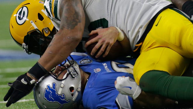 Green Bay Packers outside linebacker Julius Peppers puts the finishing touches on a sack of Detroit Lions quarterback Matthew Stafford.