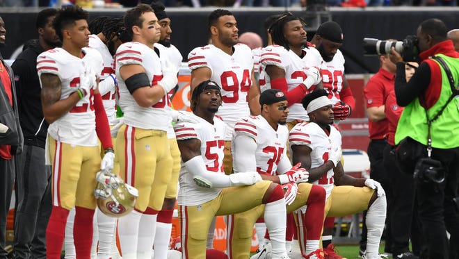 San Francisco 49ers outside linebacker Eli Harold (57), strong safety Eric Reid (35), and wide receiver Marquise Goodwin (11) kneel for the national anthem prior to the game against the Houston Texans at NRG Stadium.
