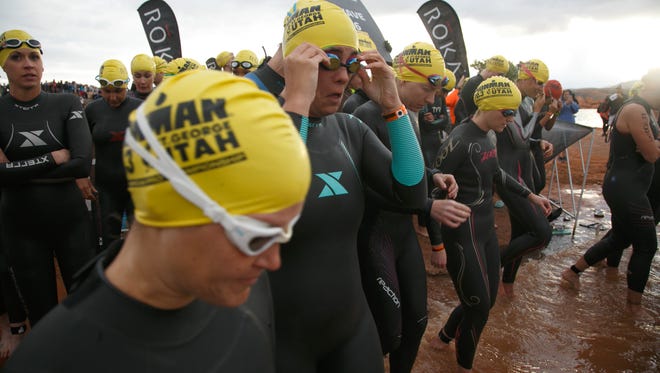 Ironman 70.3 St. George participants, including the Spectrum & Daily News' Casie Forbes, at center, enter the waters of Sand Hollow Reservoir prior to the start of their start wave Saturday, May 7, 2016.