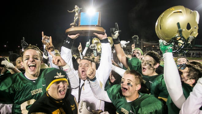 York Catholic head coach Eric Depew hoists the trophy with the team after defeating Newport, 51-21, in the District 3 2-A championship game at Boiling Springs High School on Saturday Nov. 12, 2016. Amanda J. Cain photo