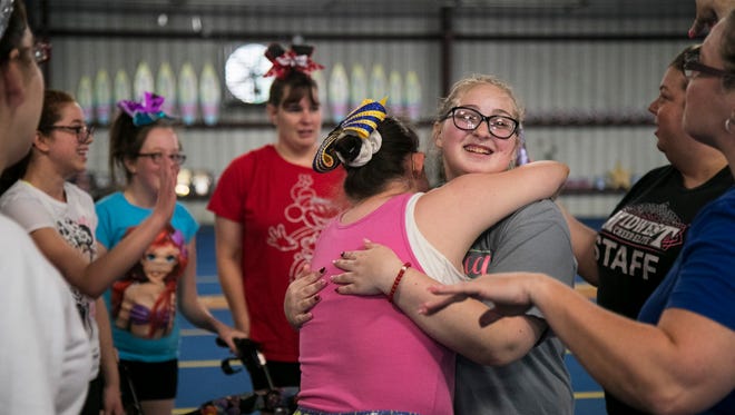 Monica Jones, left center, hugs Megan “Pinky” Howard, who is an assistant coach for the Sunlights, a special needs cheer team in Fort Myers. They were celebrating at their final practice before going to Orlando to perform in the USASF Cheerleading and Dance Worlds Championship. Jones is one of the team members.