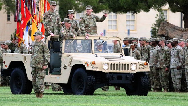 Maj. Gen. Robert “Pat” White, right, outgoing commander of the 1st Armored Division and Fort Bliss, gestures while reviewing assembled troops with incoming commander Maj. Gen. Patrick E. Matlock, top left, Lt. Gen. Laura J. Richardson, center, and Col. John M. Cushing, bottom, as they ride in a Humvee during a change of command ceremony Thursday on post.