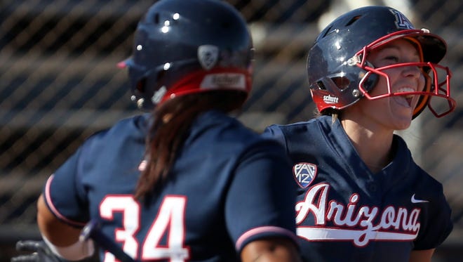 Arizona's Eva Watson (14) gives out a yell after coming home on Mandie Perez's  (55) homer in the third inning of their NCAA Regional championship game at Hillenbrand Stadium, Sunday, May 21, 2017, Tucson, Ariz.