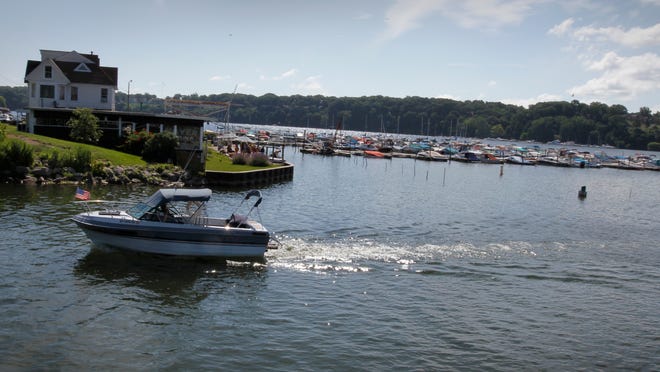 
A boater passes Mayer Marina as he heads out to Lake Ontario from Irondequoit Bay using the Irondequoit Bay outlet in July of 2010. Federal lawmakers say they have found the funding to fully dredge the outlet and the Port of Rochester. The projects will begin this summer. 
