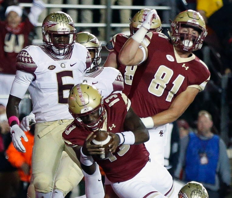 Boston College quarterback Anthony Brown (13) scores in front of Florida State linebacker Matthew Thomas (6) during the half of an NCAA college football game in Boston, Friday, Oct. 27, 2017.