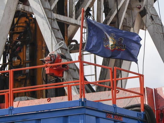 In this file photo from March 12, 2020, the flag of the Commonwealth of Pennsylvania flies on the drilling rig as work continues at a shale gas well drilling site in St. Mary's, Pa. Pennsylvania attorney general Josh Shapiro is scheduled to release results on Thursday June 25, 2020 of a grand jury investigation into natural gas hydraulic fracturing. The fracking process has raised environmental concerns while turning the state into a major energy producer.