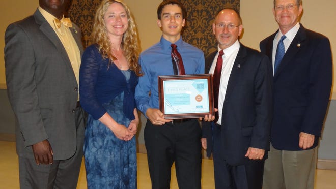 
Zack Varrato, center, stands with his graphic design teacher, Kelli Gehrke, and representatives from B’nai B’rith International during his award ceremony.
