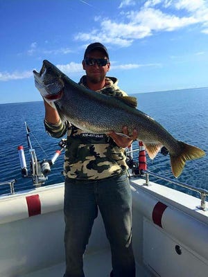Aaron Berg, captain of Dumper Dan III, holds up a Lake Trout.