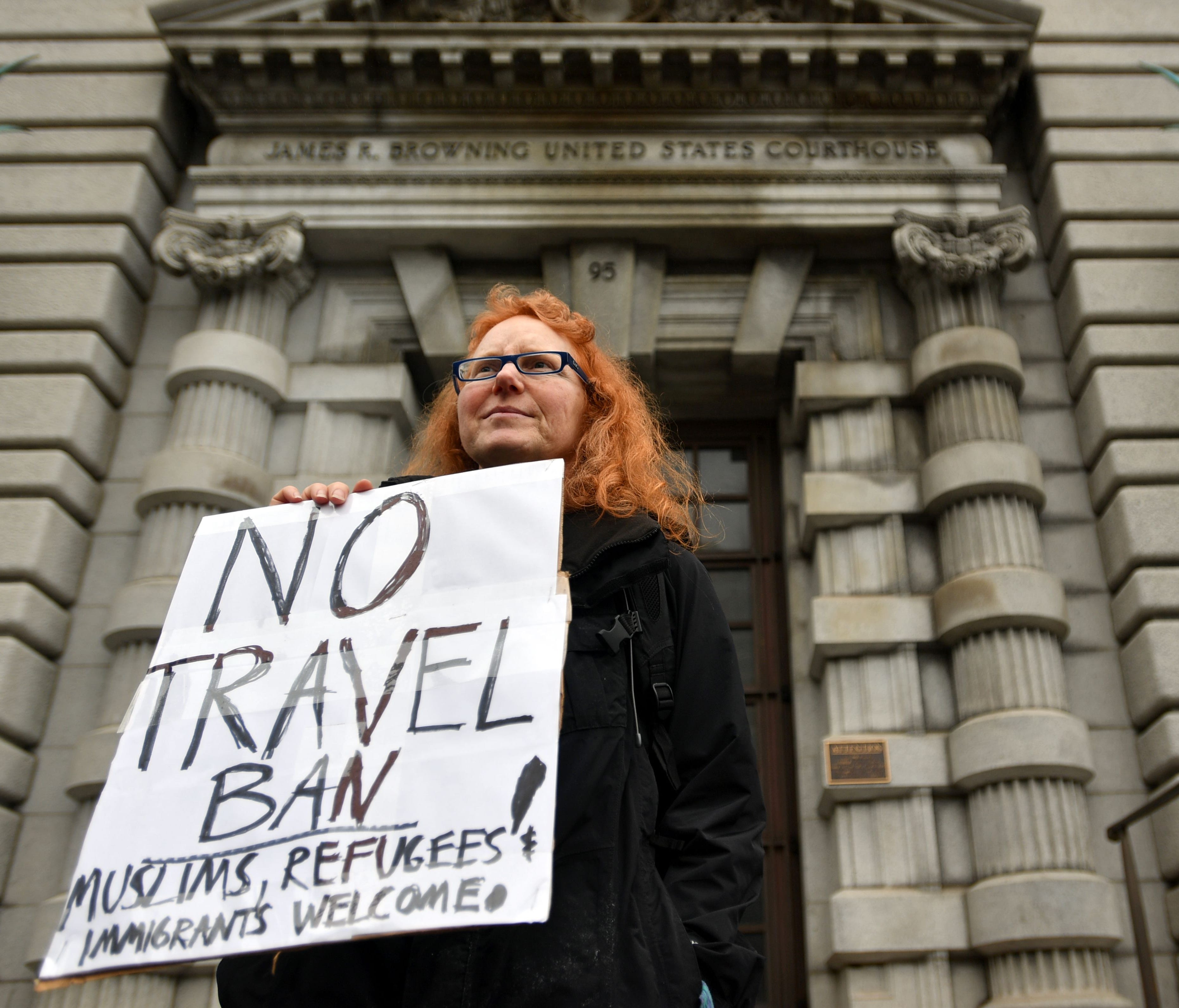 Beth Kohn holds up a sign in front of the 9th U.S. Circuit Court of Appeals in San Francisco, on Feb. 7, 2017. The court heard oral arguments on whether to lift a nationwide suspension of President Trump's travel ban targeting citizens of seven Musli